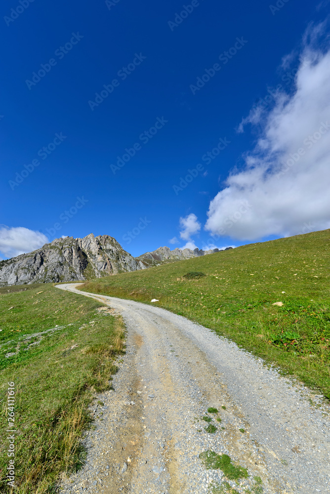 path crossing mountain to peak under blue sky