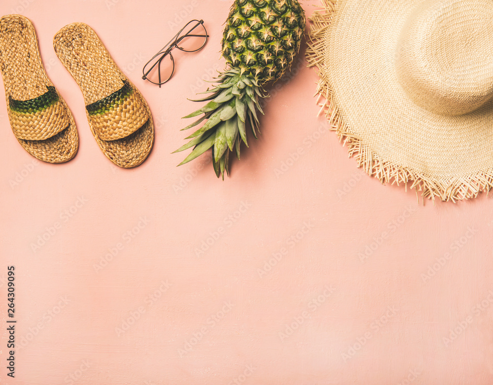 Summer apparel items. Flat-lay of summer flip flops, sunglasses, straw sunhat?? and fresh pineapple 
