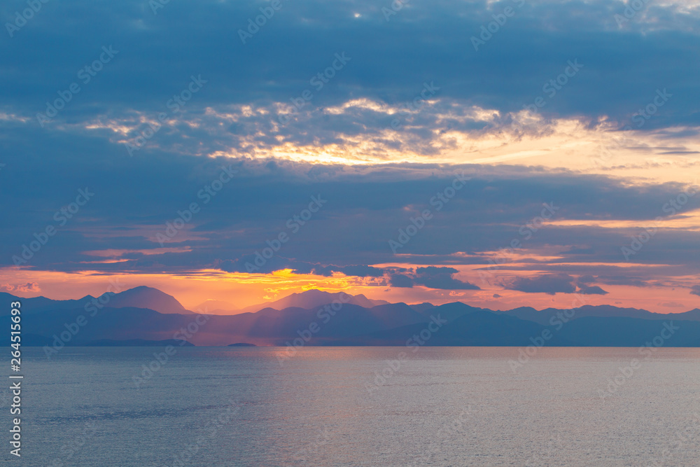 Summer sunrise on coast, Corfu island, Greece. Beach with perfect views of the mainland Greece mount