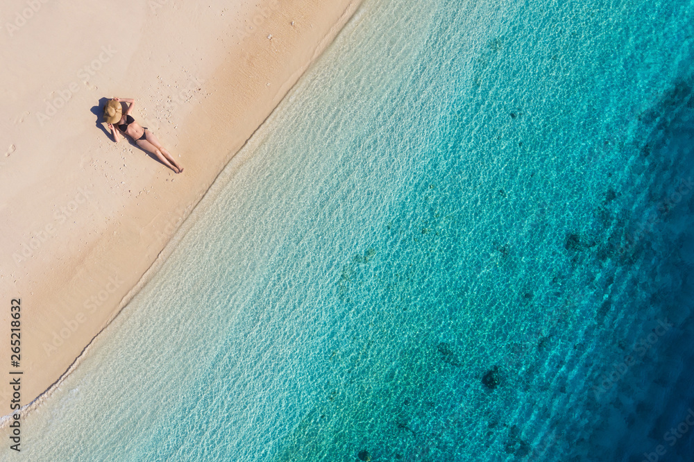 印度尼西亚巴厘岛海滩上一个女孩的鸟瞰图。度假和冒险。海滩和绿松石w