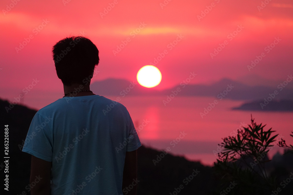 特写：一个正在放暑假的年轻人在达尔马提亚观看日落