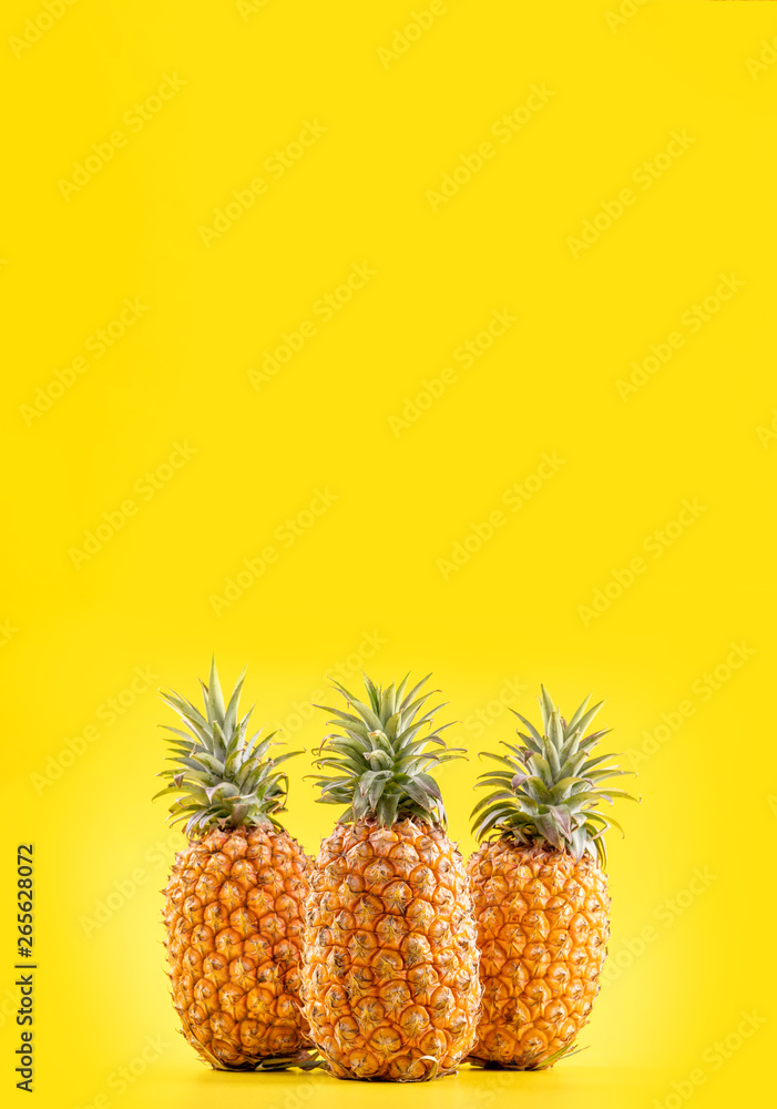 明亮的黄色背景上隔离着美丽的新鲜菠萝，夏季时令水果设计理念pa