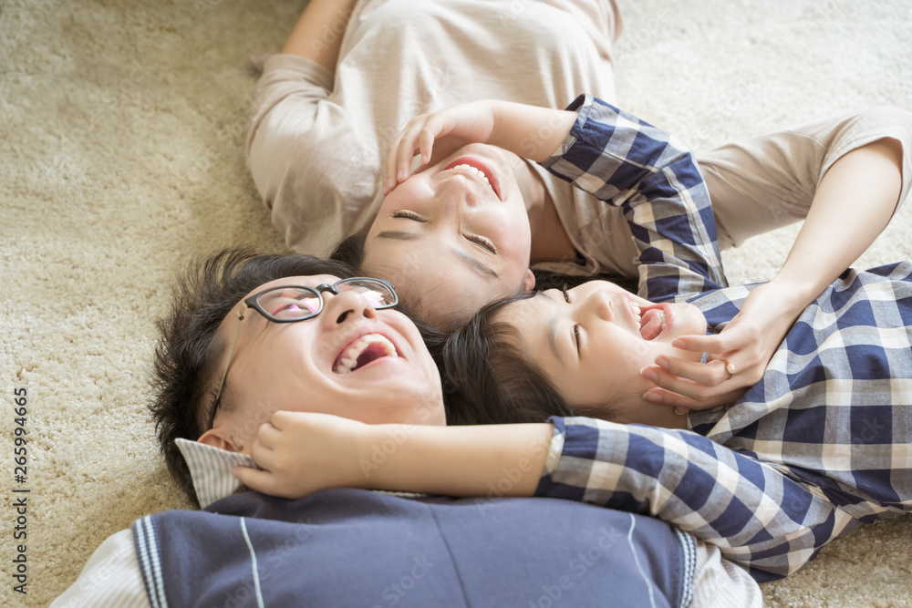肖像快乐的亚洲家庭躺在客厅里玩耍