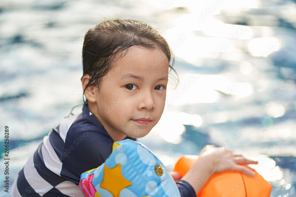 亚洲小女孩在游泳池玩得很开心