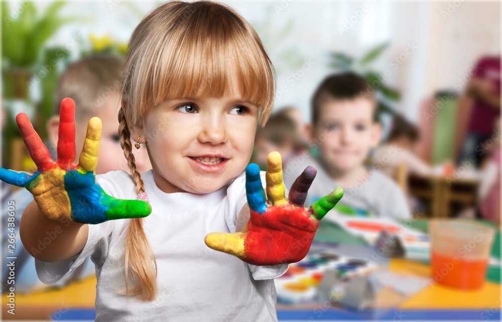 课堂背景上画着五颜六色的手的可爱小女孩
