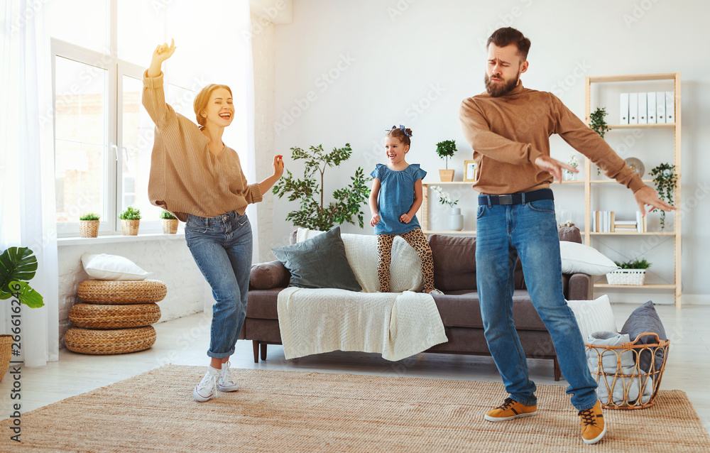 幸福的家庭母亲父亲和孩子女儿在家跳舞。