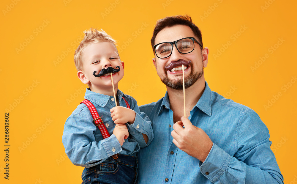 父亲节快乐！有趣的爸爸和留着胡子的儿子在黄色背景上嬉戏。