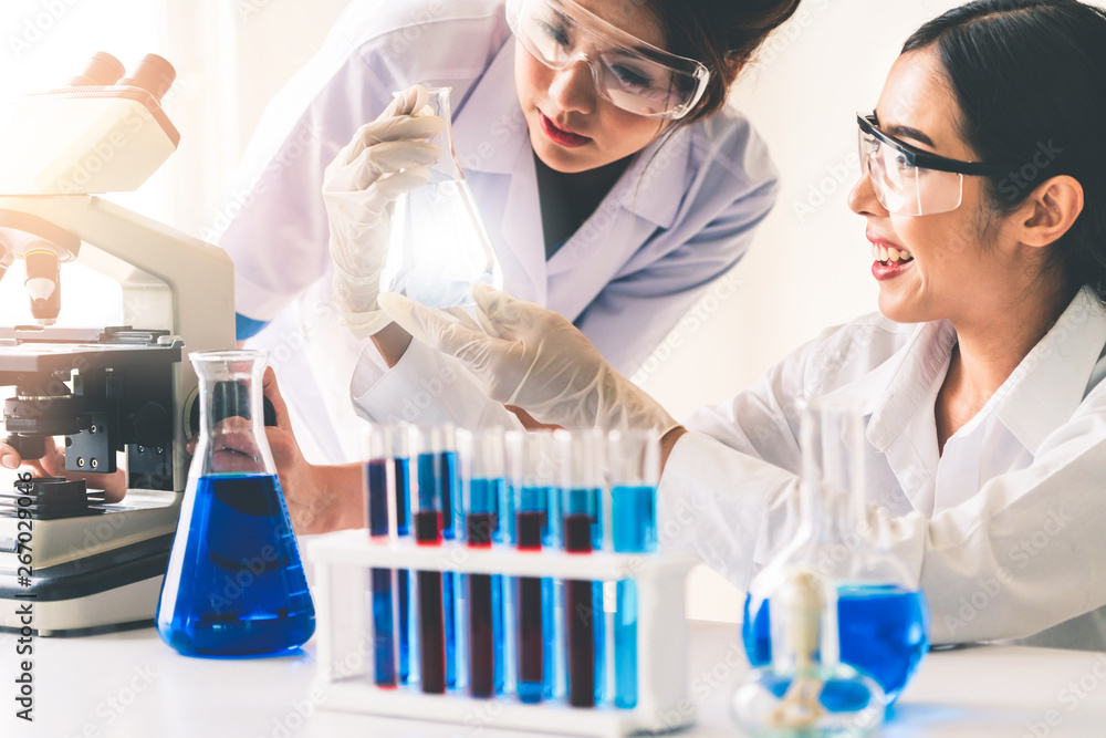 Group of scientists wearing lab coat working in laboratory while examining biochemistry sample in te