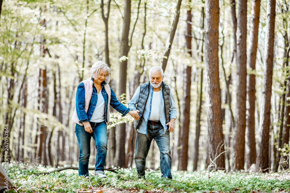 老年夫妇一起在森林里散步，享受大自然和退休后的空闲时间