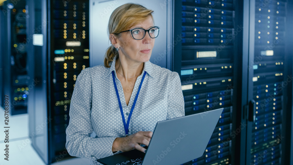 数据中心人像拍摄：女IT技术员在笔记本电脑上运行维护程序，Contro