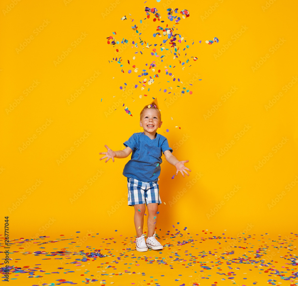 happy birthday child boy with confetti on yellow background.