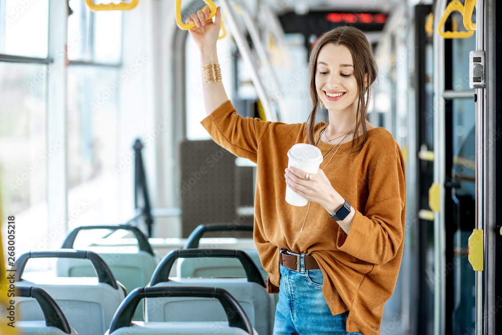 年轻快乐的乘客在公共交通工具上享受旅行，站在现代的咖啡里