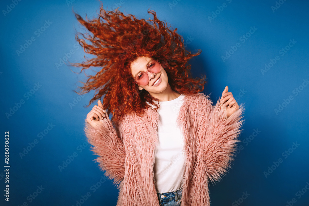 美丽的红发女人在彩色背景下