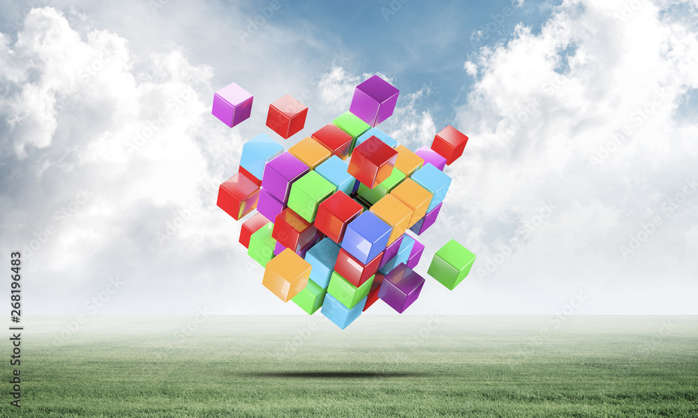 Abstract colorful cubes on green meadow