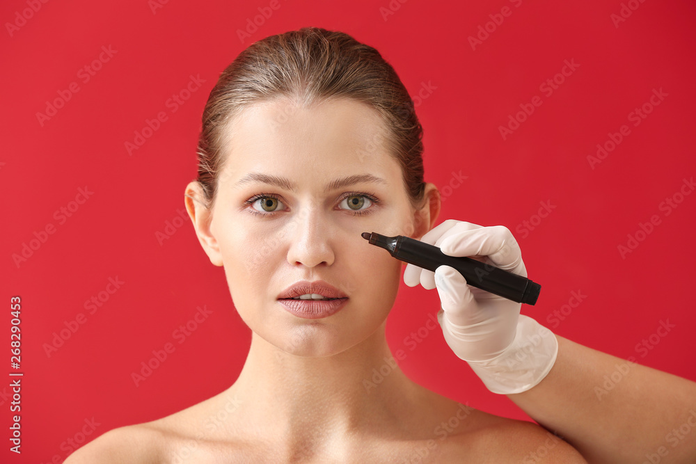 整形外科医生在彩色背景下对女性面部进行标记