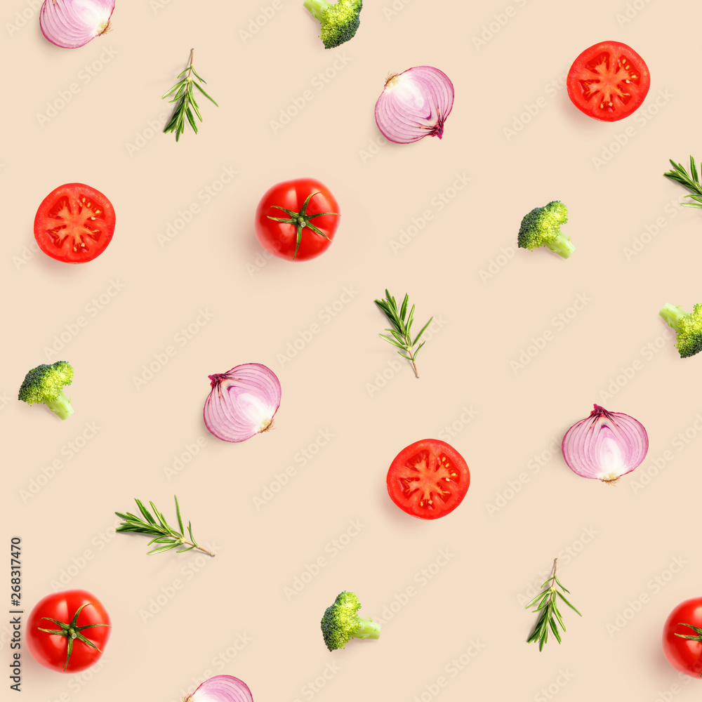 米色背景下由番茄、西兰花和洋葱制成的创意图案。平躺。食物概念。