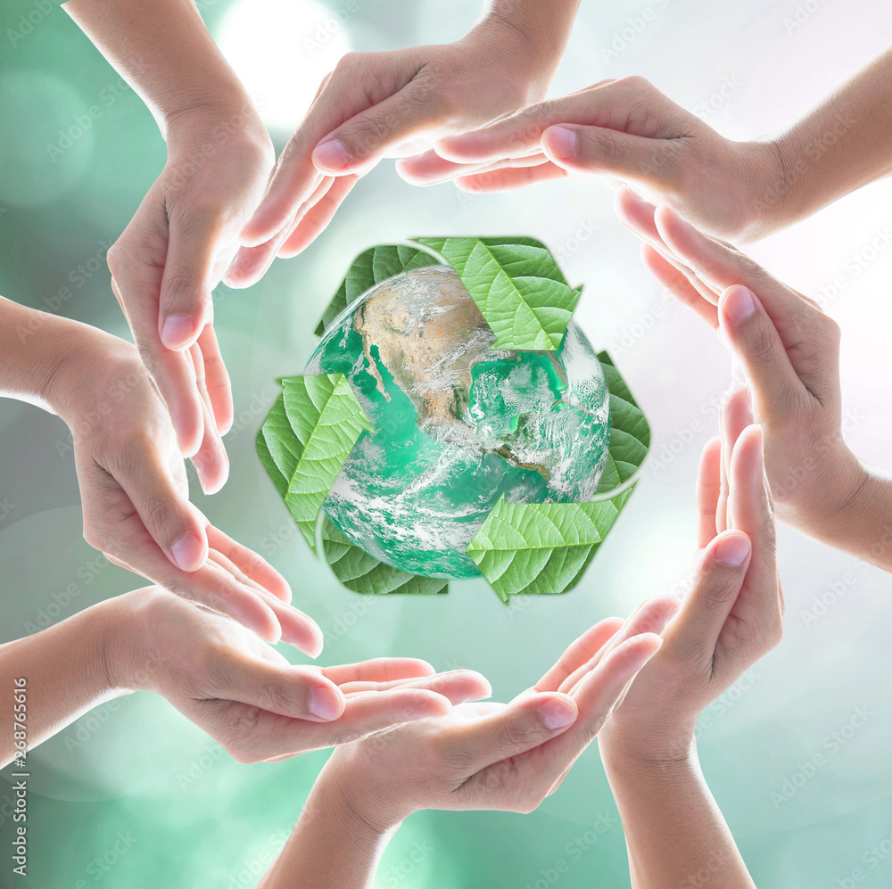 双手环绕着绿色星球，由模糊bokeh上的回收标志叶子保护。这个ima的元素