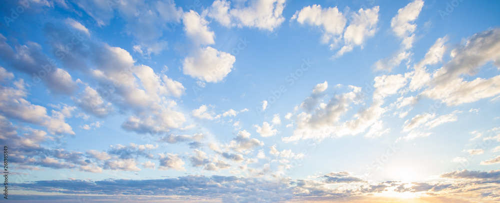 蓝天白云背景，天空中有云朵和橙色太阳的美丽景观
