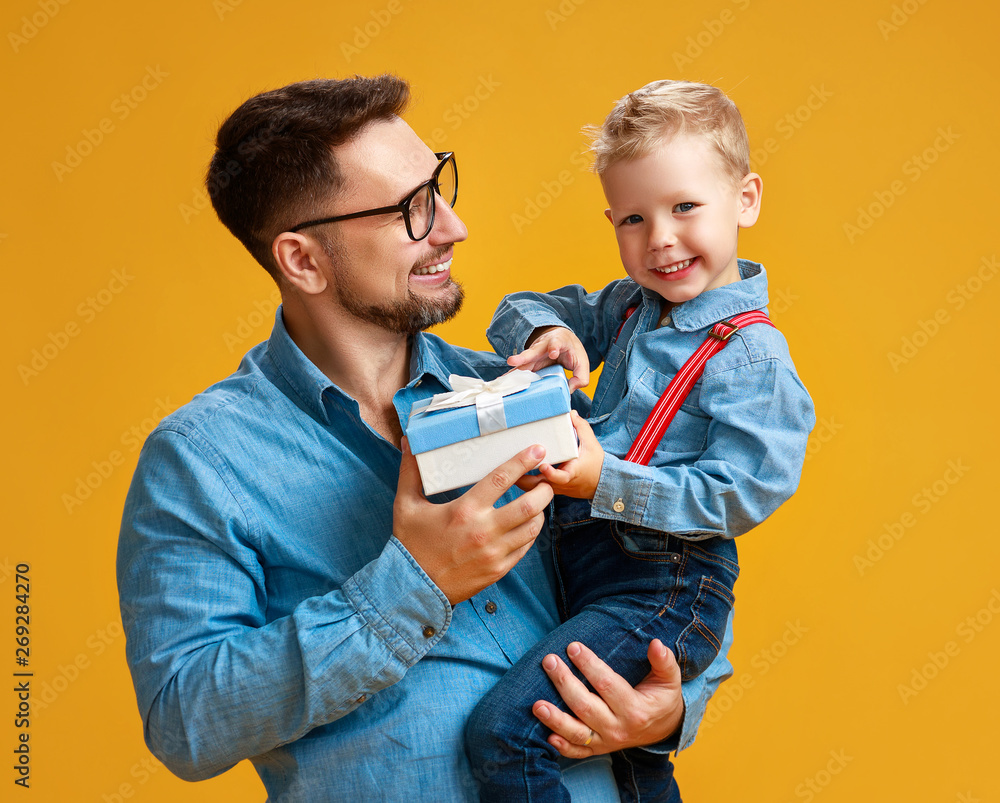 happy fathers day! cute dad and son hugging on yellow background
