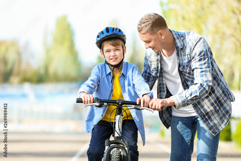 父亲教儿子在户外骑自行车