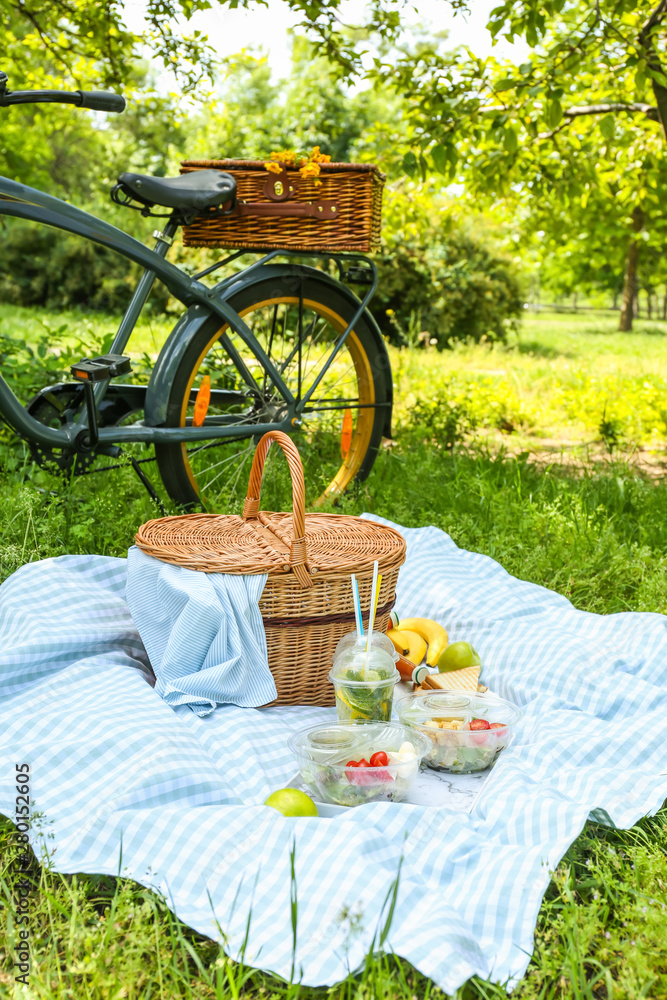 自行车和柳条篮，里面有美味的食物和饮料，可以在公园里浪漫野餐