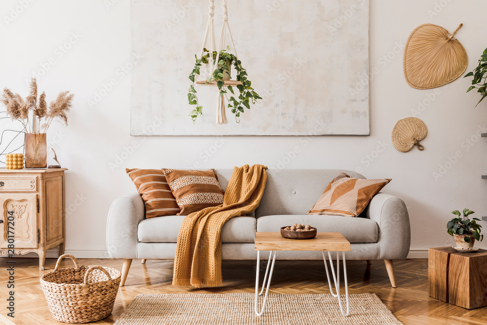 客厅室内时尚的波西米亚风格，配有设计灰色沙发、木制茶几和通讯器