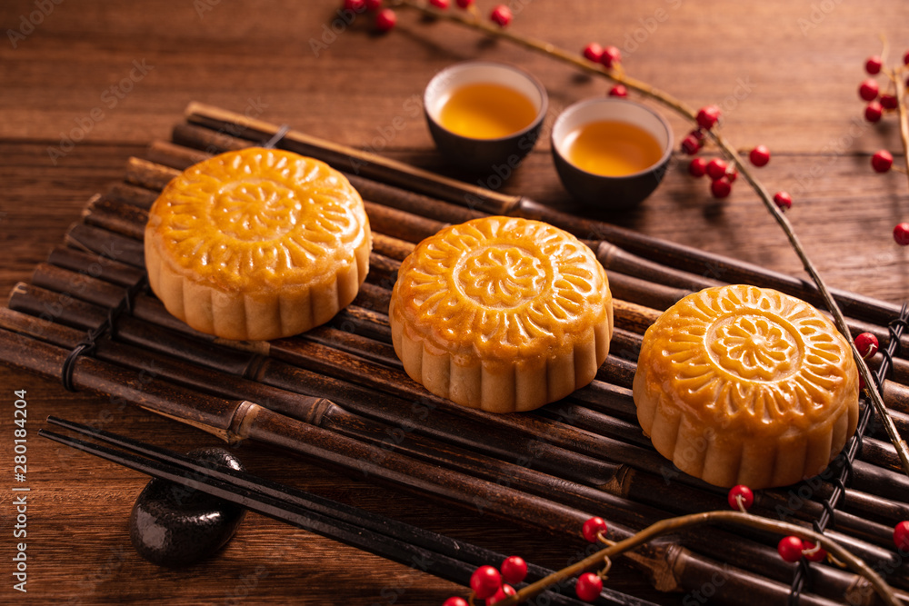 Moon cake Mooncake table setting - Round shaped Chinese traditional pastry with tea cups on wooden b