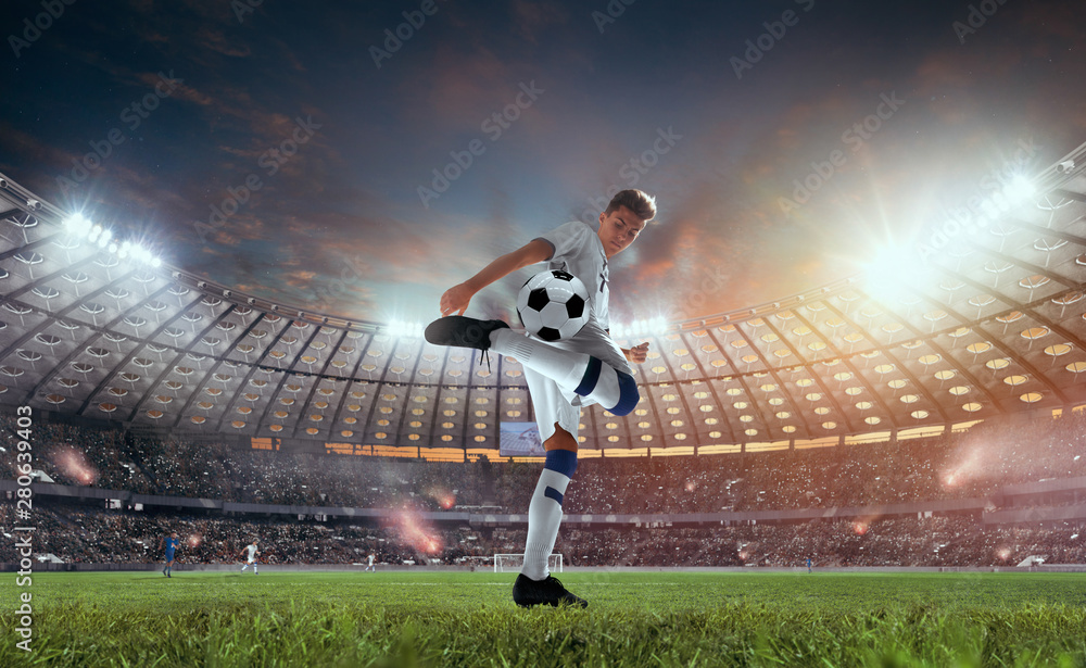 日落时分，足球运动员在职业体育场进行比赛。