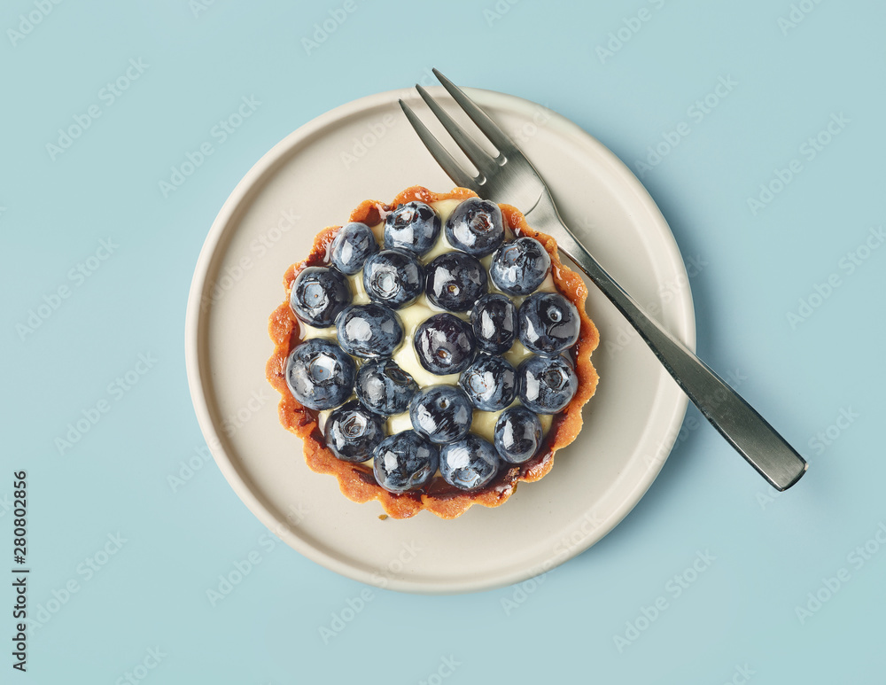 blueberry tart on light blue background