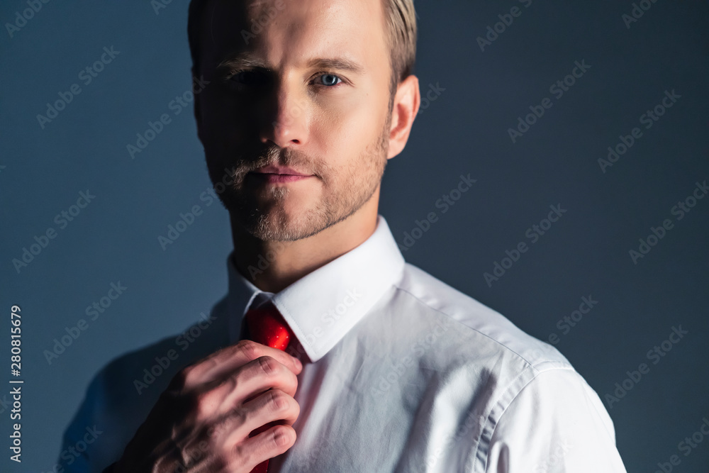 聪明英俊的高加索商人白色衬衫手触红色领带准备行动姿势灰色b