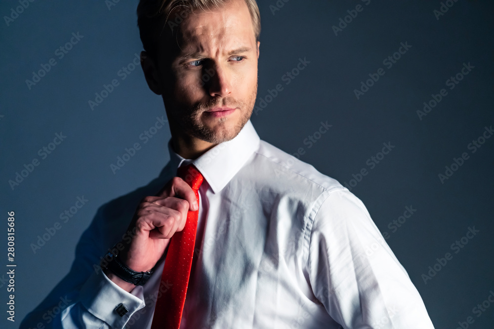 聪明英俊的高加索商人白色衬衫手触红色领带准备行动姿势灰色b