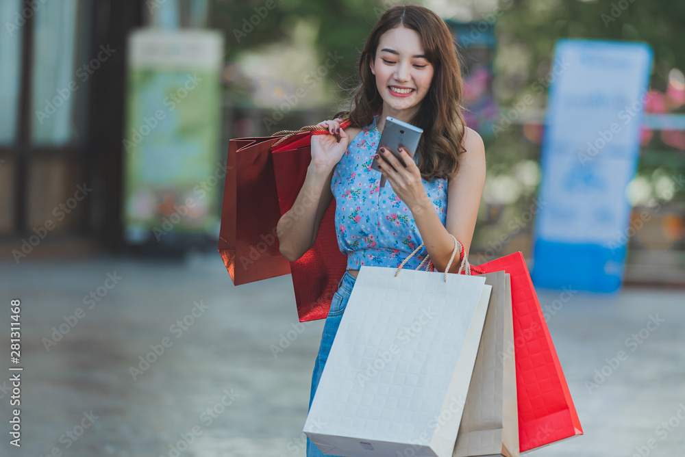 购物理念的快乐时光，亚洲女人在购物中心拿着购物袋。