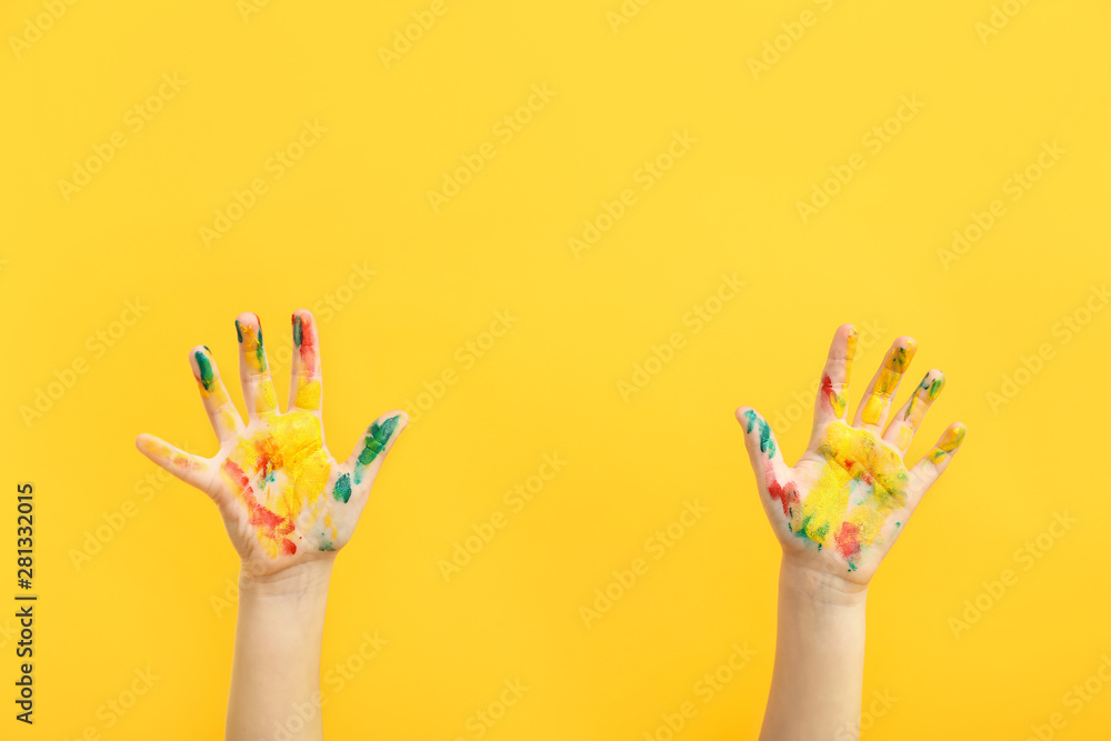 Childs hands in paint on color background