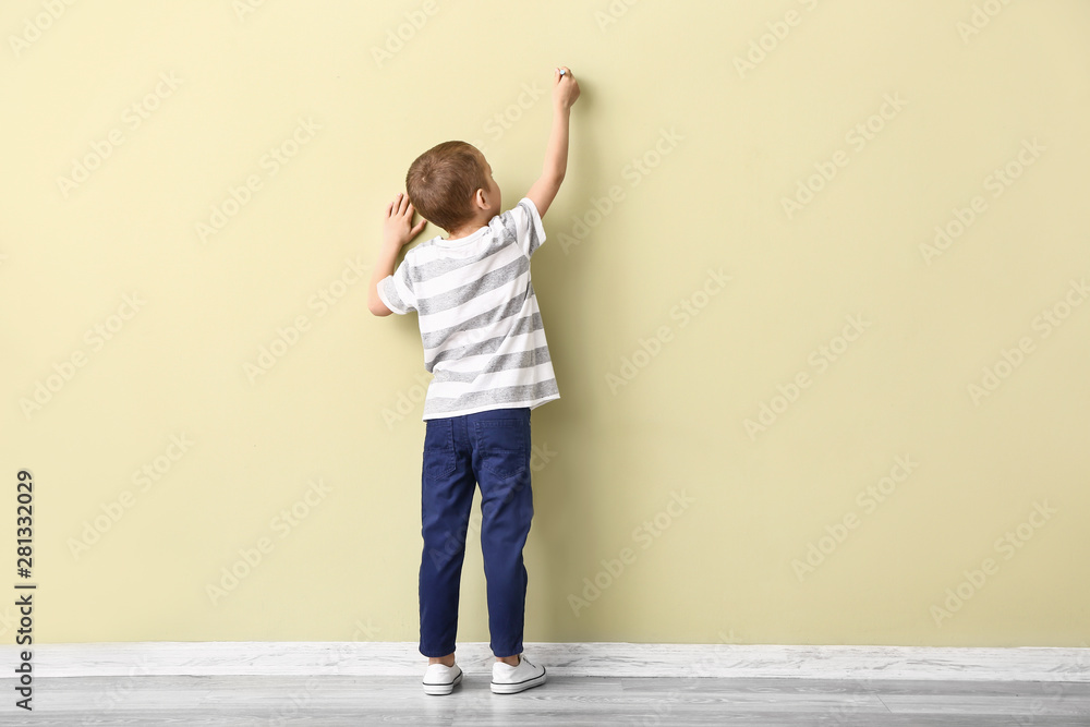 小男孩在彩色墙上画画