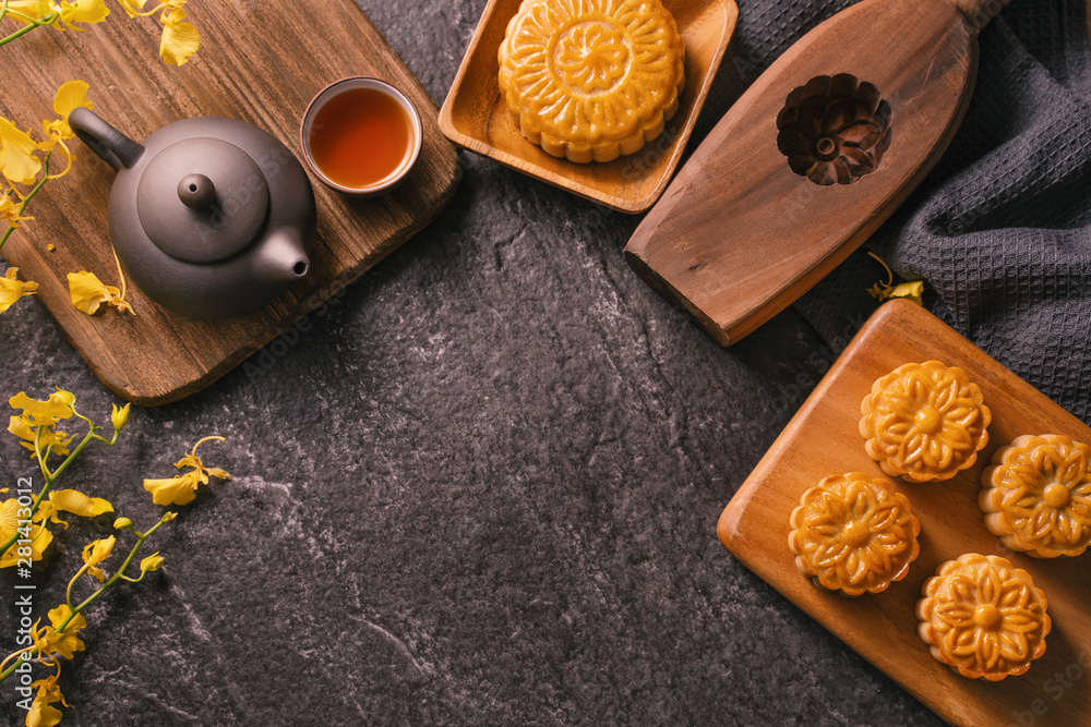 中秋节传统美食理念-黑石板桌上的漂亮月饼配茶，啪