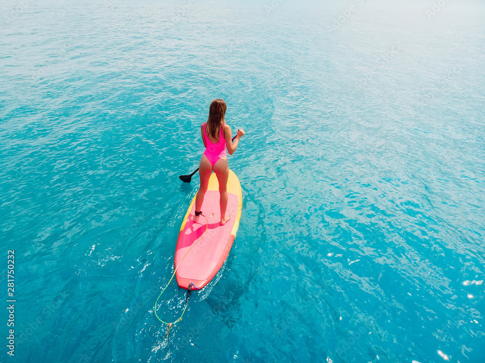 海洋中站立式桨板上的女性鸟瞰图。