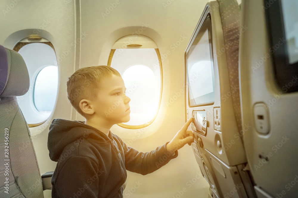可爱的小男孩坐飞机旅行。孩子坐在飞机旁
