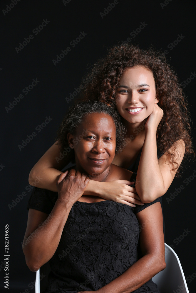 黑色背景下的非裔美国妇女和她的女儿的肖像