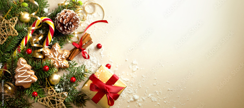 浅金色背景上的圣诞装饰构图，带有红色ri的美丽金色礼盒
