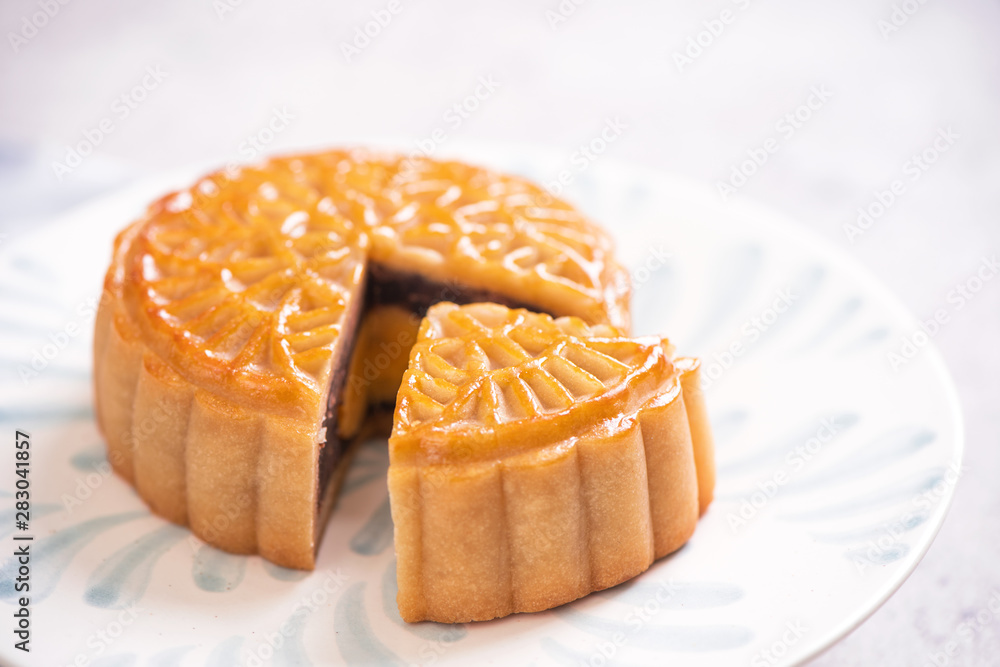 中秋节传统美食理念-惠特蓝纹板上的漂亮切月饼