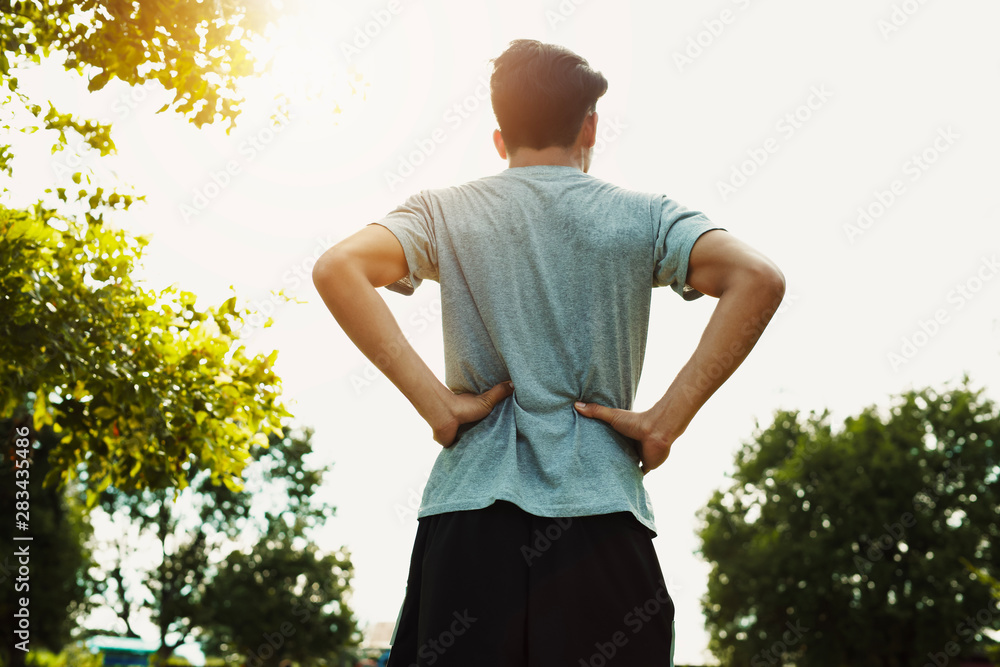 Runners back pain after Jogging at the park with sunset