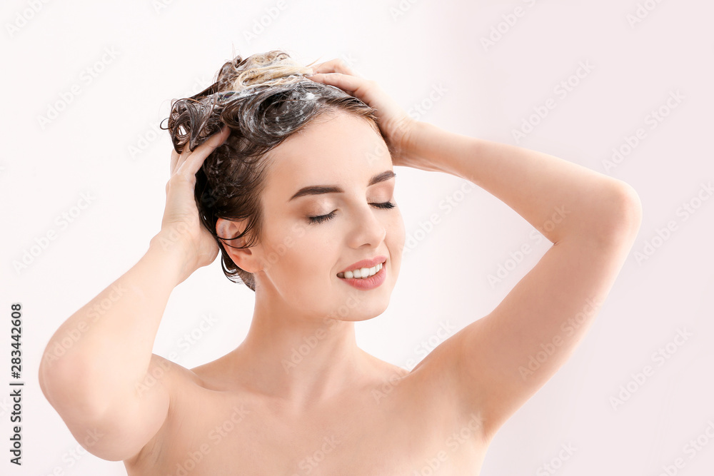 美丽的年轻女子在淋浴时洗头