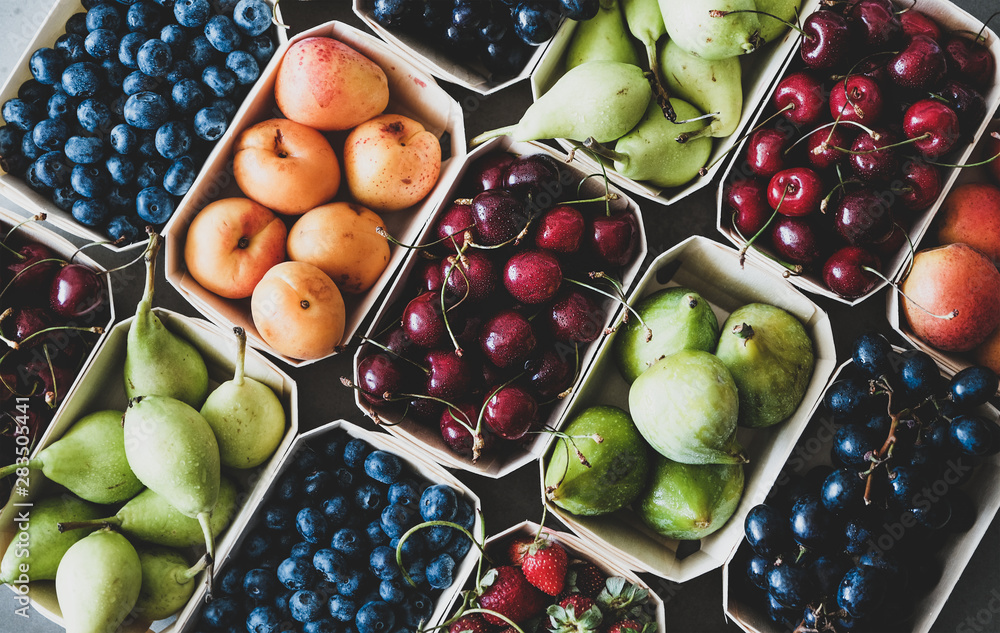 夏季水果和浆果品种。成熟的草莓、樱桃、葡萄、蓝莓、梨等平铺而成。