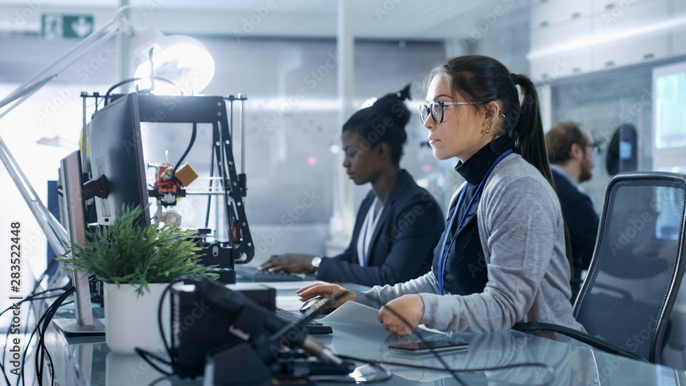 在现代高科技实验室与同事一起使用电脑的白人女性。