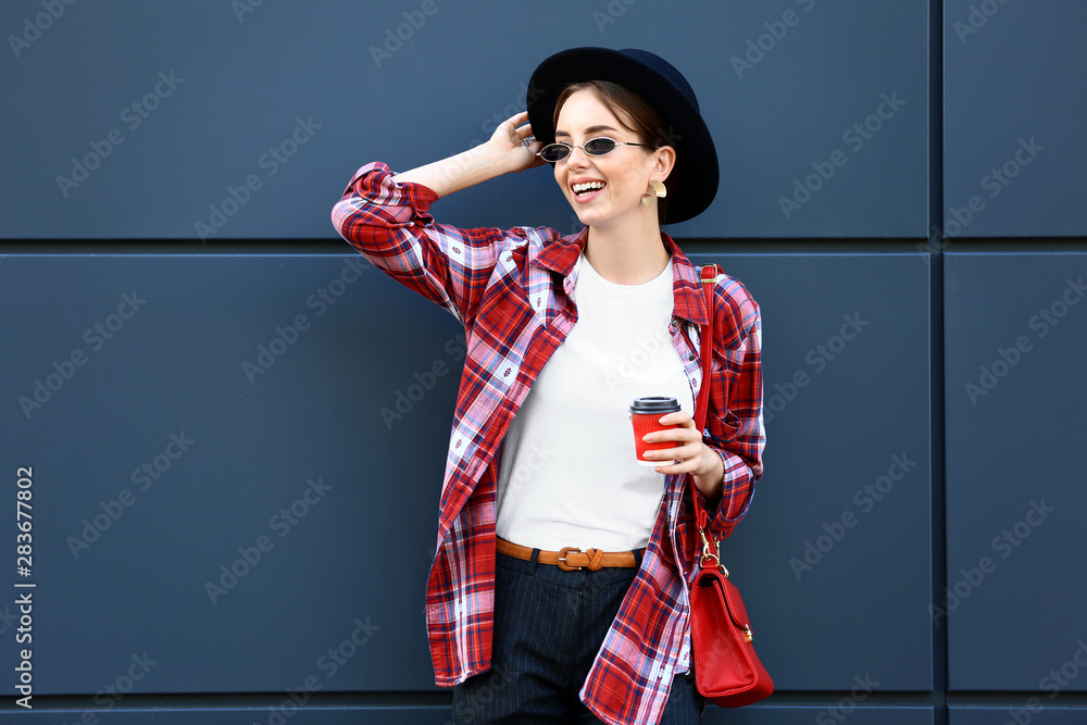 时尚的年轻女人在户外喝咖啡