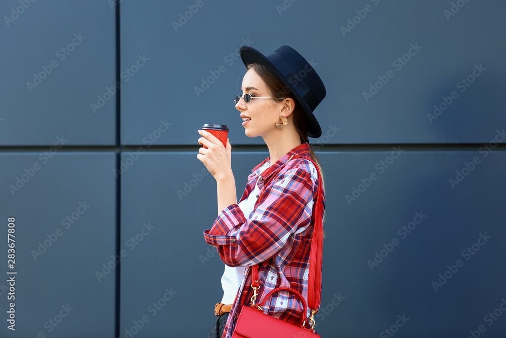 时尚年轻女子在户外喝咖啡