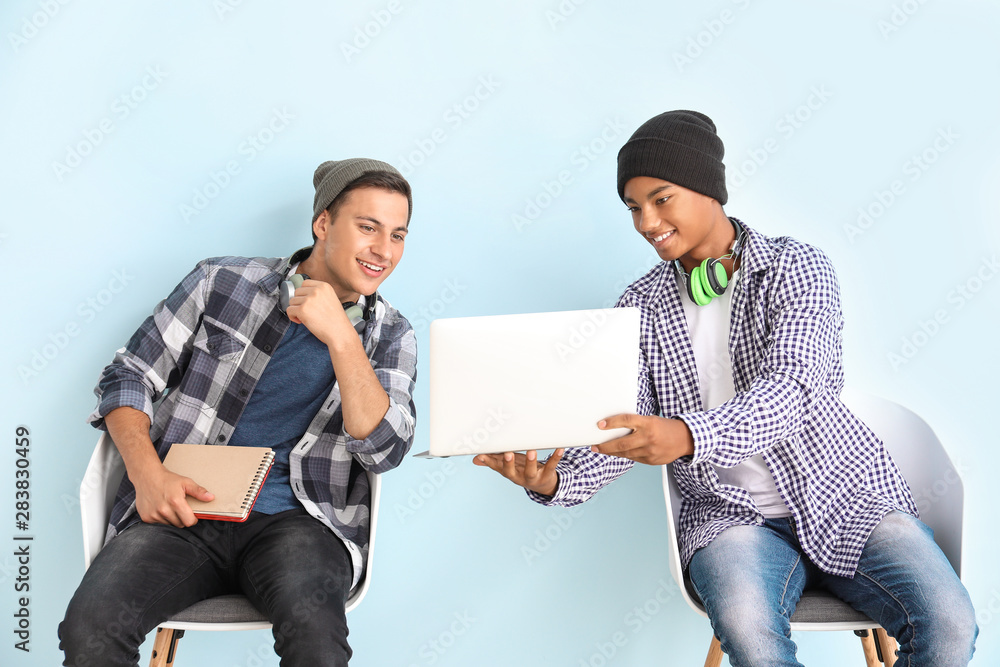 彩色背景下带笔记本电脑的年轻学生肖像
