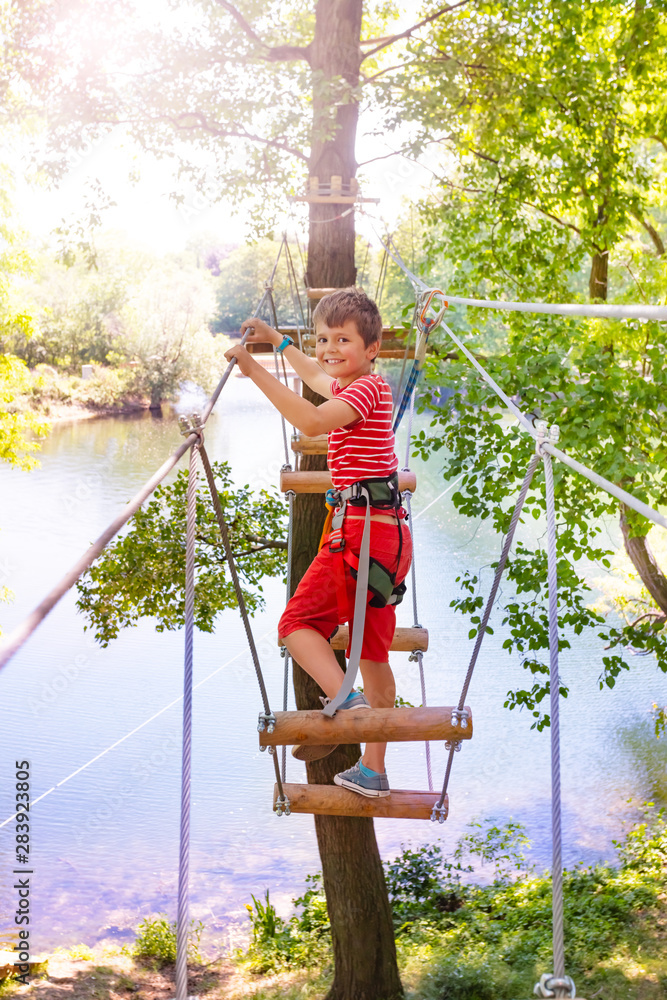 冒险公园里的男孩和高树绳桥