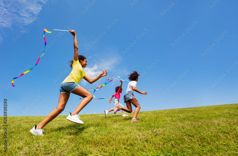 一群女孩在公园里奔跑挥舞丝带