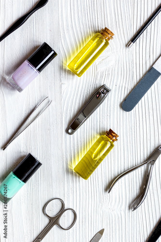 nail polish, cuticle oil and manicure set on wooden background